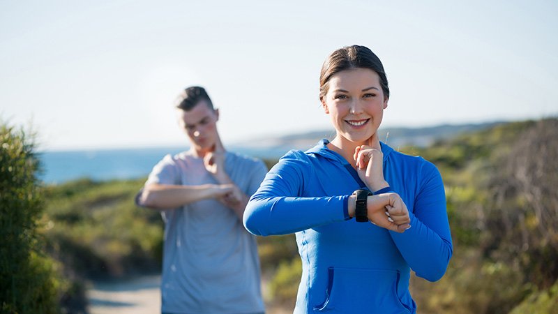 Par på tur sjekker pulsklokke.