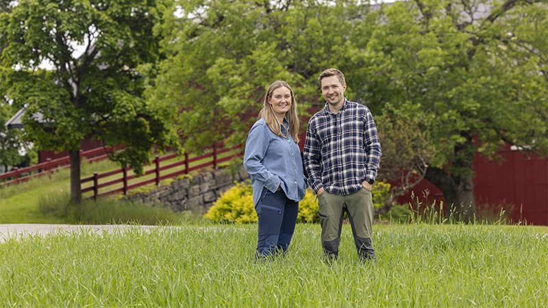 Annicken og Hans Fredrik Skappel poserer i enga på Skapal gård i Ringsaker