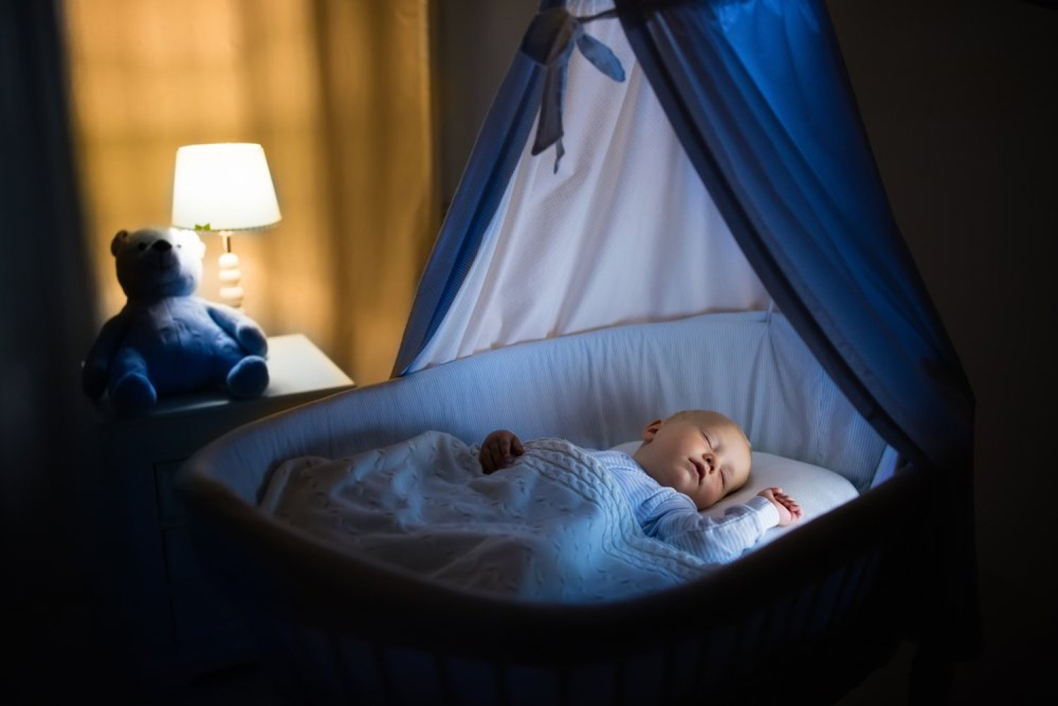Bildet viser en baby som ligger i en babyseng og sover