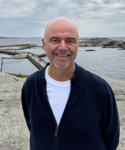 Profilbilde av Stein Kvalheim med svaberg og sjø i bakgrunnen