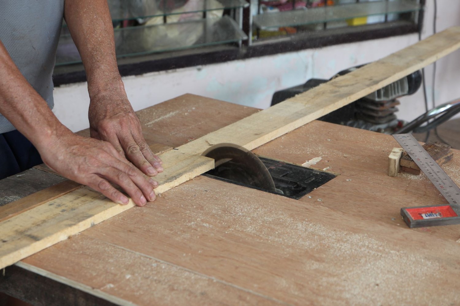 Bildet viser en snekker som kapper en planke.