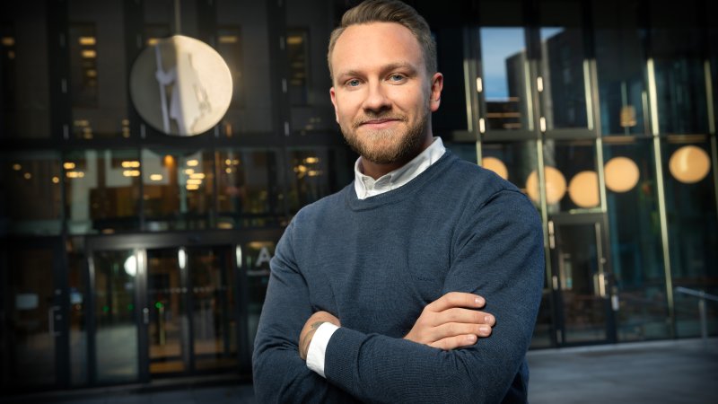 Jonas Ulriksen står med armene i kors foran Gjensidige-bygget.
