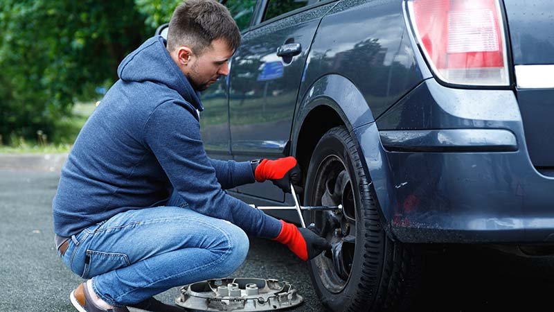 Mann som skifter bildekk