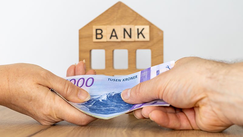 To personer som utveksler en bunke med sedler.