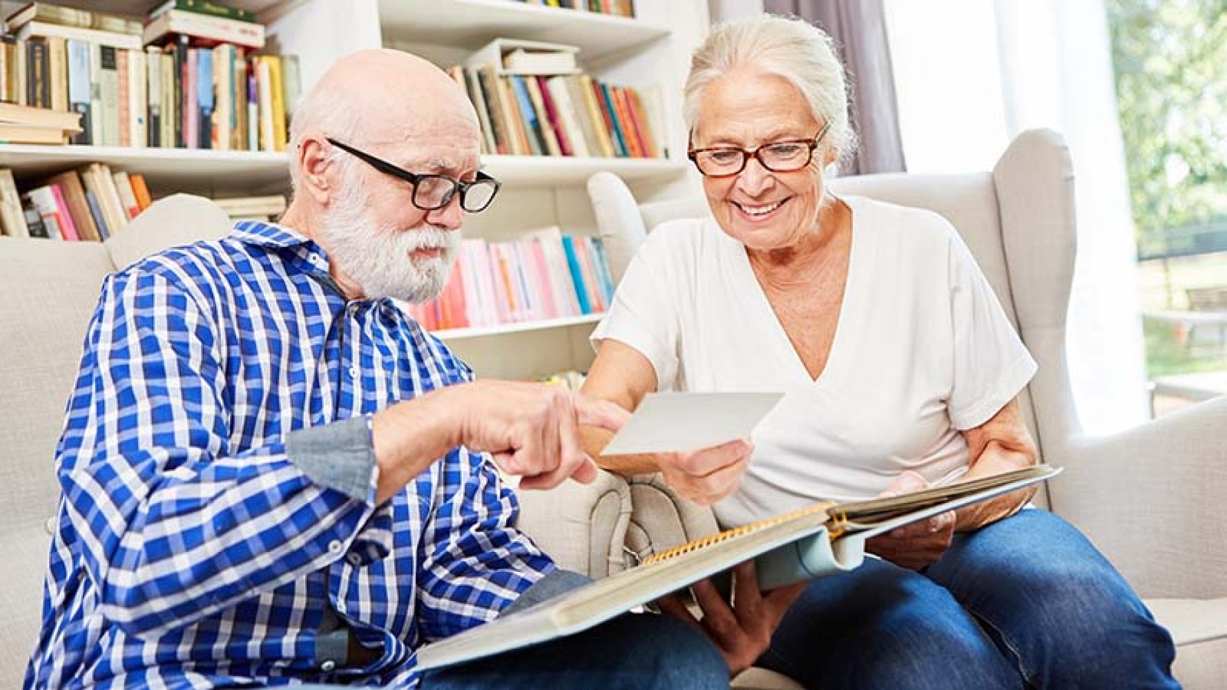 Ektepar som ser i fotoalbum.