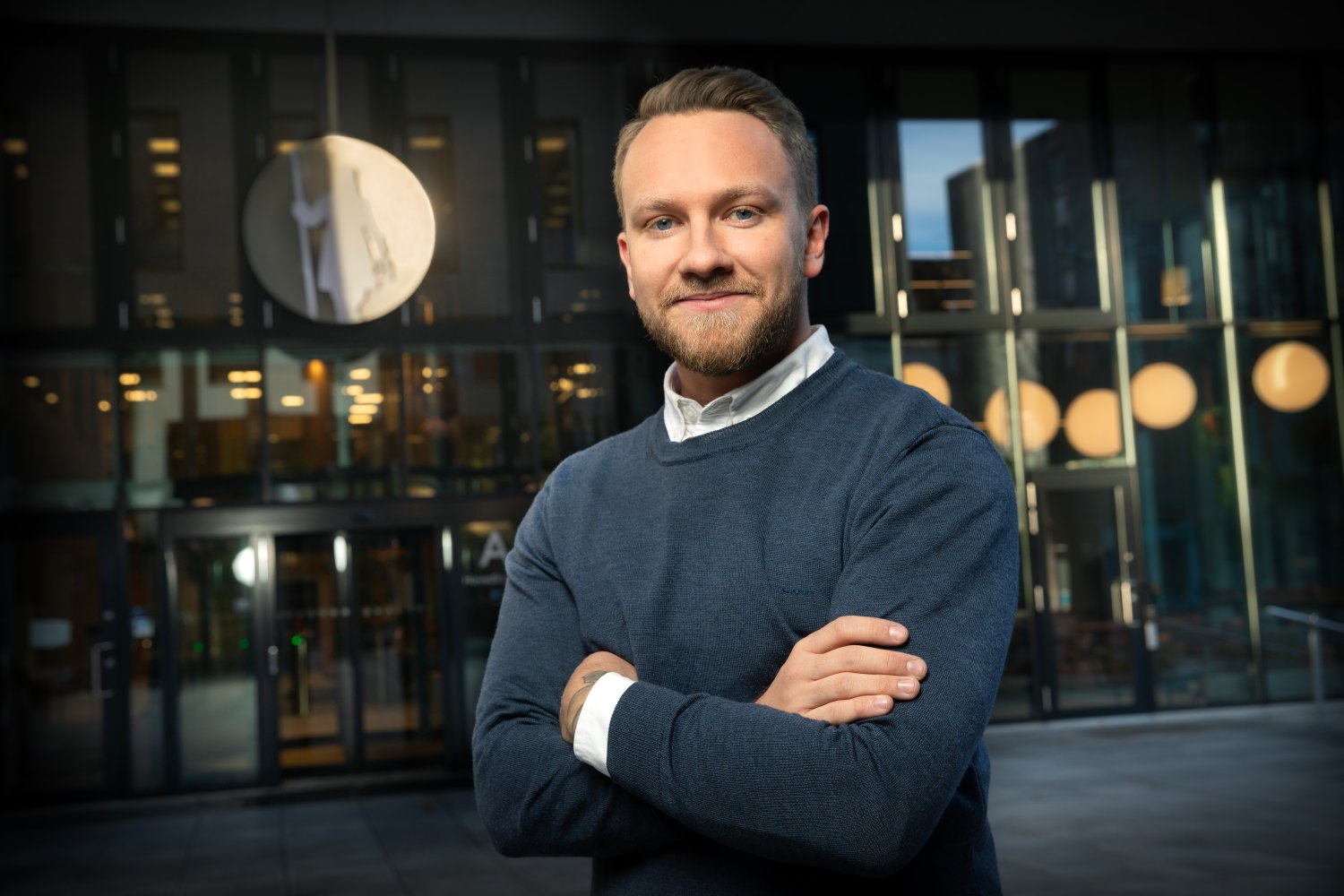 Jonas Ulriksen står med armene i kors foran Gjensidige-bygget.