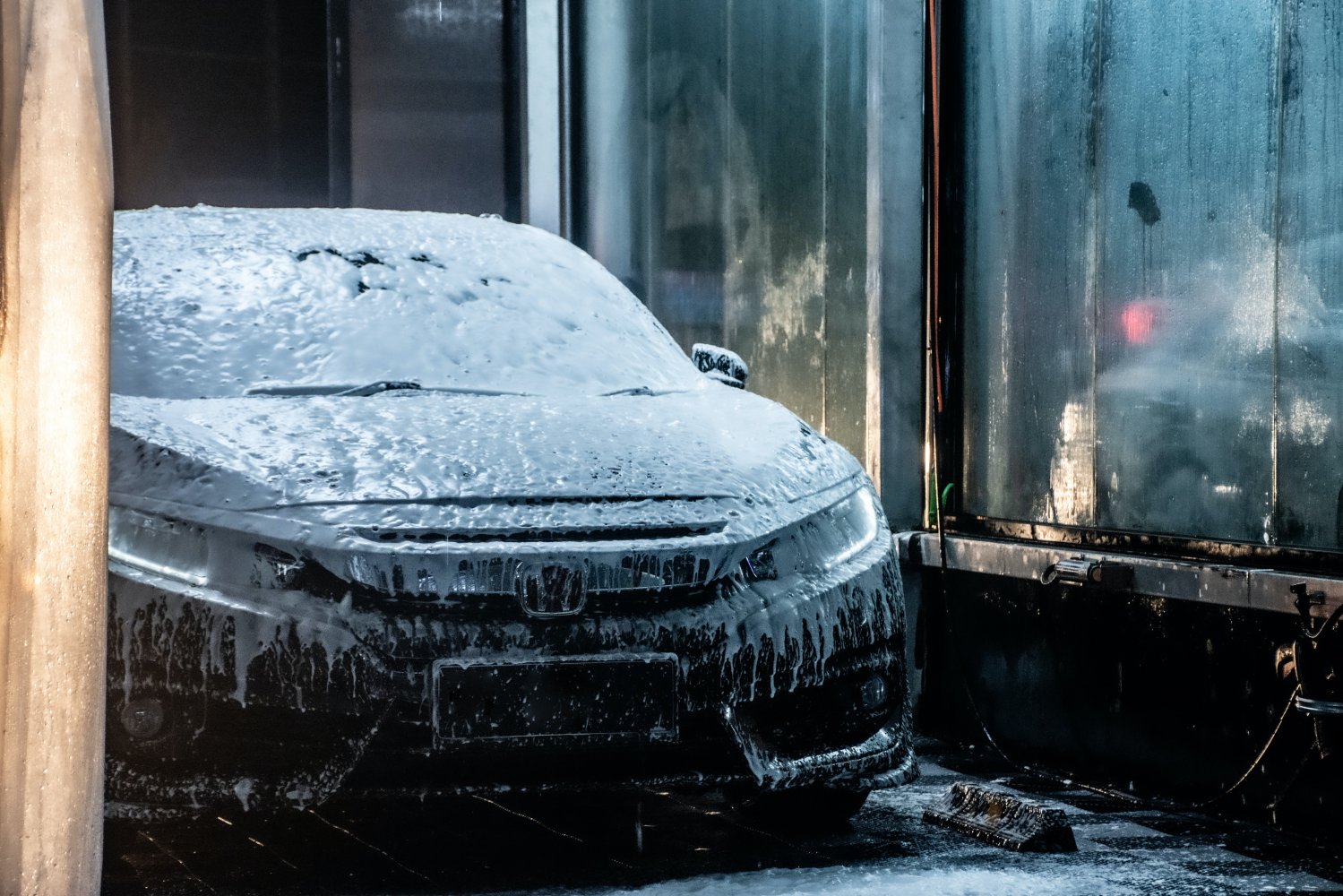 Bronsefarget Land Rover med såpeskum i vaskehall.