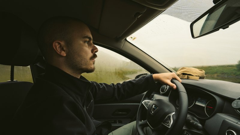 Mann kjører bil.