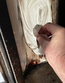 Nærbilde av mann som vasker bort sot fra glasset i peisen. Foto: Tormod M. Aadnesen