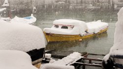 Båt til kai på vinteren. Mye nedbør i form av snø.