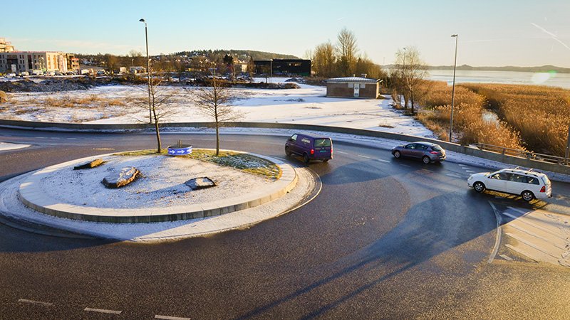 Rundkjøring. Biler. Snø. Vann